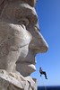 Paul Horsted > Park Service worker dangles beneath Abe Lincoln carving at Mt. Rushmore during an inspection of the faces. ©Paul Horsted/www.dakotahoto.com.